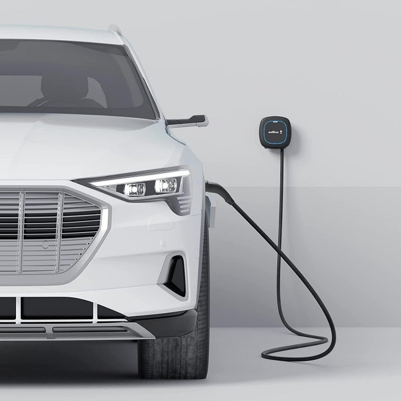 Cargador de coche eléctrico Wallbox Pulsar Max instalado y conectado a un coche eléctrico; imagen ambiental de catálogo.